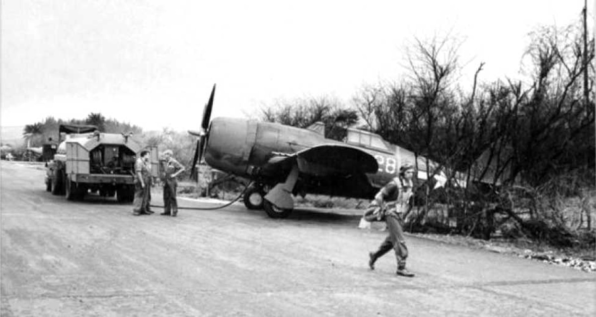 historic fighter plane during world war 2 being refueled with a truck by men in uniforms