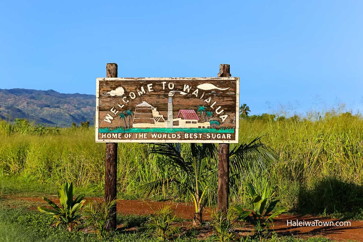 wooden sign to Waialua Sugar Mill on a green grassy field