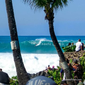 man surfing big wave on north shore surf competition at waimea