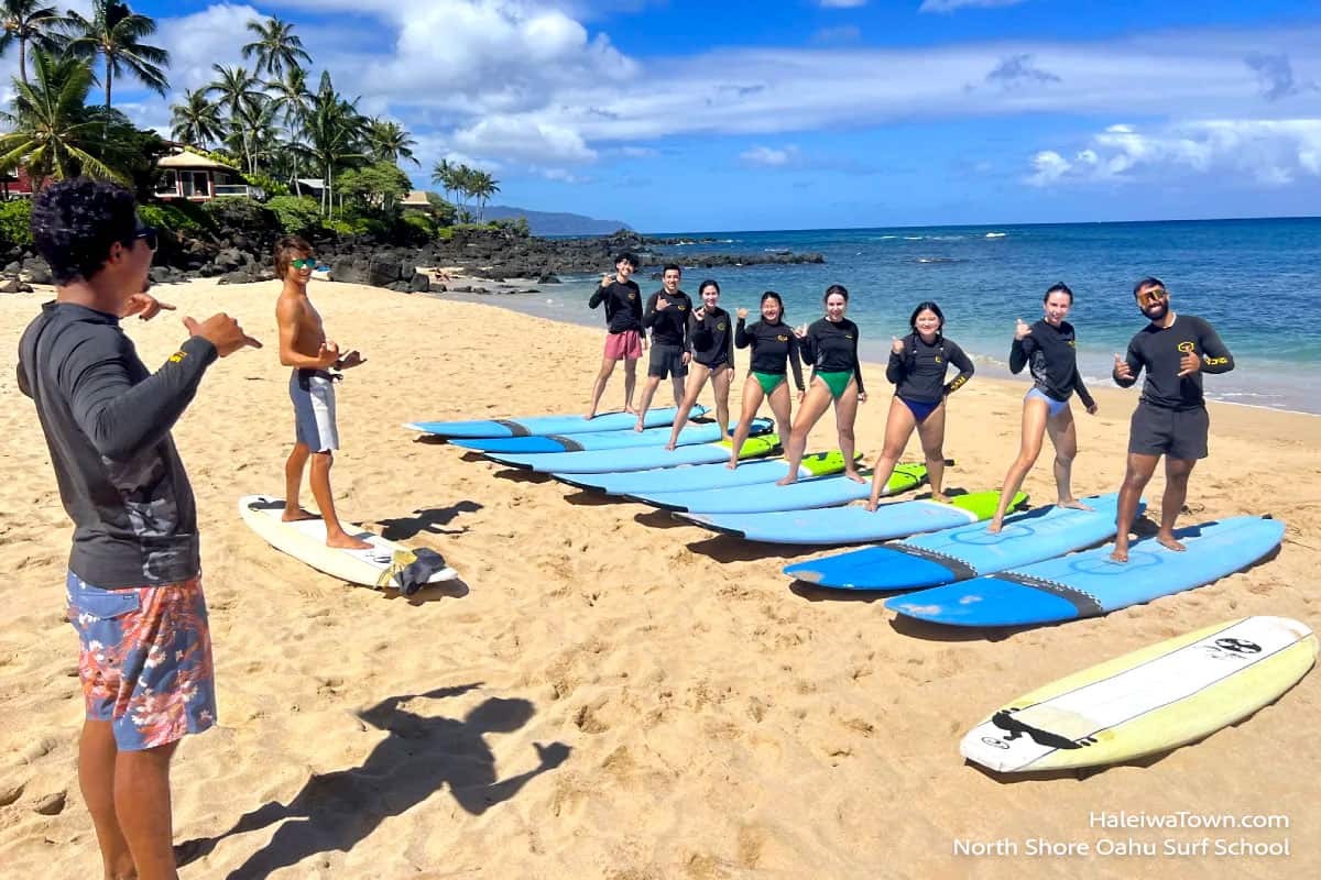 instructors giving surf lessons to a group of people on the beach at Chuns Reef