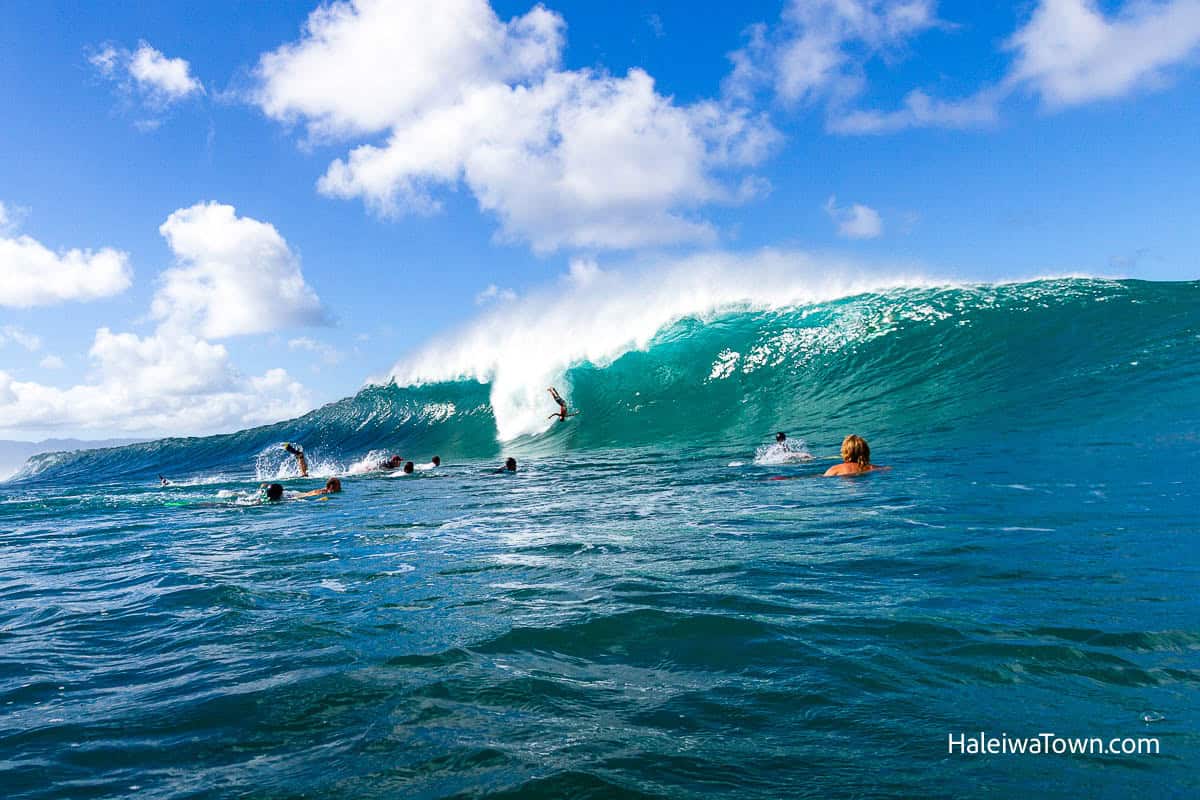 surfer wiping out on a big wave at pipeline
